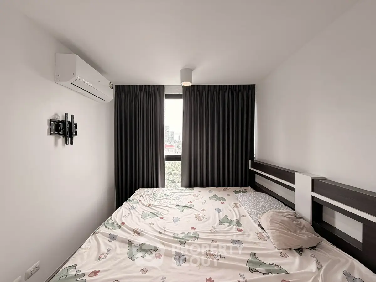 Cozy bedroom with large window and modern air conditioning unit, featuring stylish curtains and playful bedding.