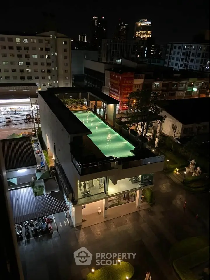 Stunning rooftop pool with city skyline view at night, perfect for luxury urban living.