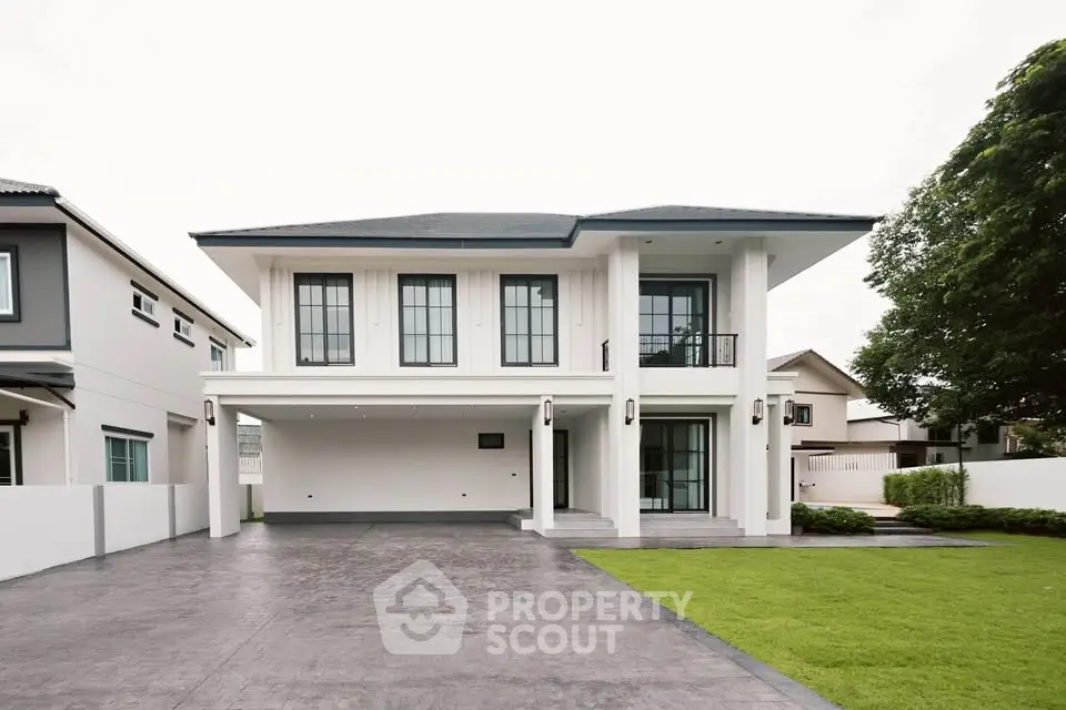 Elegant two-story modern house with spacious driveway and lush green lawn, perfect for family living.