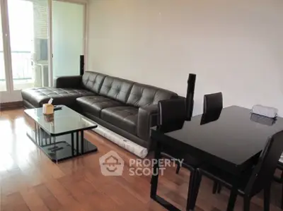 Modern living room with sleek black furniture and hardwood floors