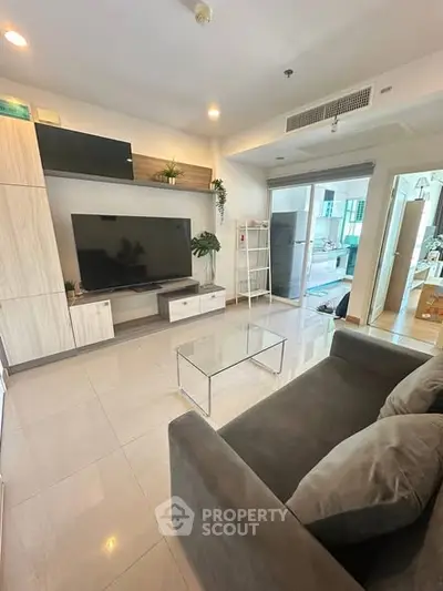 Modern living room with sleek design, large TV, and comfortable sofa in a stylish apartment.