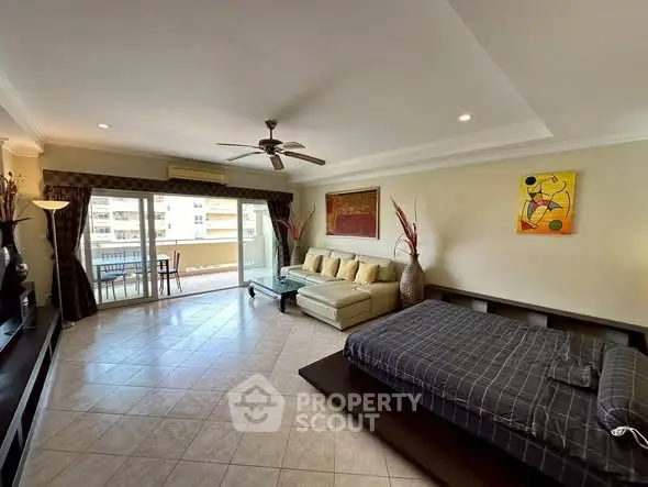 Spacious living room with modern decor and large balcony access.