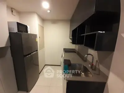 Modern kitchen with sleek cabinets and stainless steel appliances in a compact layout.