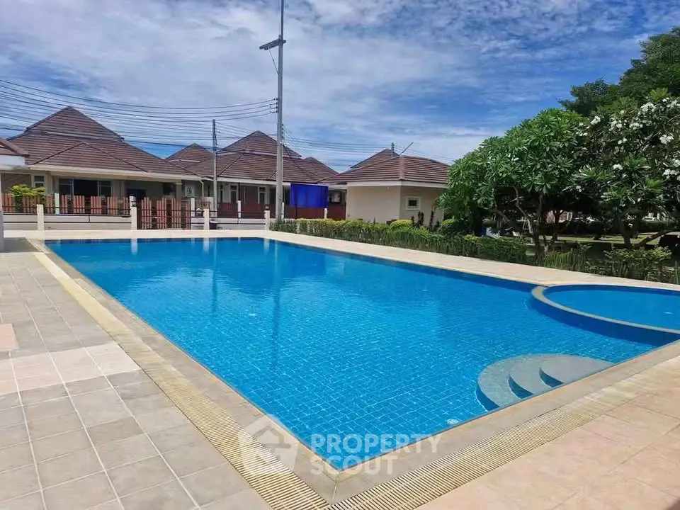Luxurious residential pool area with clear blue water and modern surroundings.