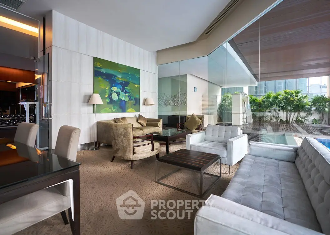 Luxurious modern living room with glass walls and pool view, featuring elegant furniture and contemporary art.