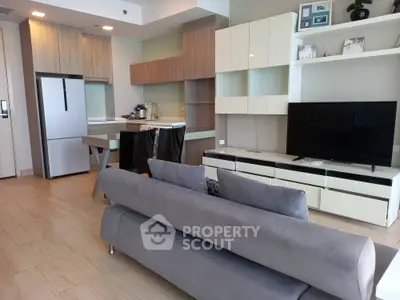 Modern living room with open kitchen, sleek furniture, and stylish decor in a contemporary apartment.