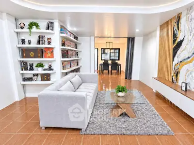 Modern living room with stylish decor and open layout leading to dining area.