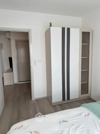Modern bedroom with sleek wardrobe and cozy bed in a stylish apartment.