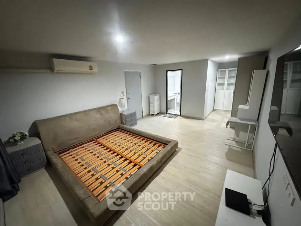 Spacious bedroom with modern decor and ample storage in a stylish apartment.