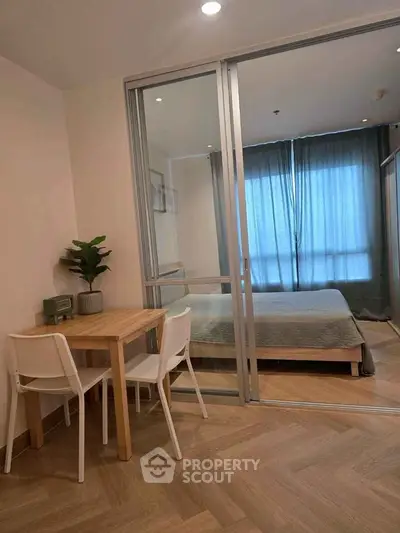 Modern bedroom with sliding glass doors and cozy dining area, perfect for urban living.