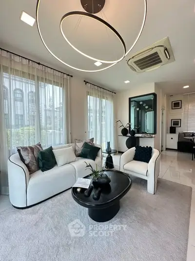 Luxurious modern living room with elegant decor and large windows, featuring a stylish sofa and chic lighting.