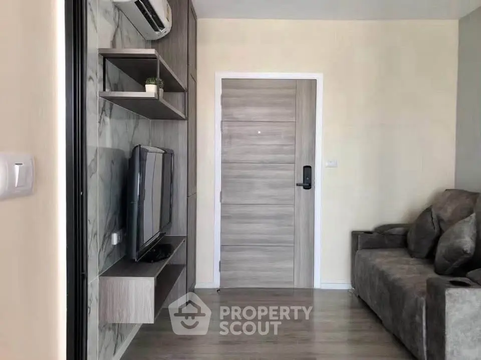 Modern living room with sleek TV setup and comfortable sofa in stylish apartment.
