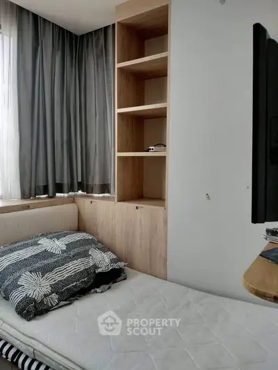 Cozy bedroom with built-in shelves and natural light, perfect for modern living.
