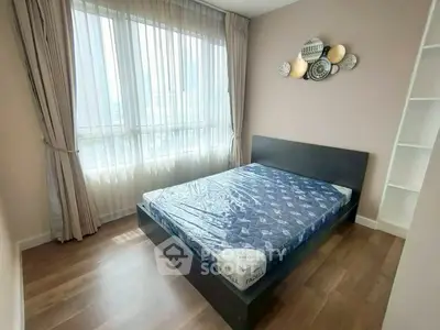 Modern bedroom with large window and stylish decor in a cozy apartment.