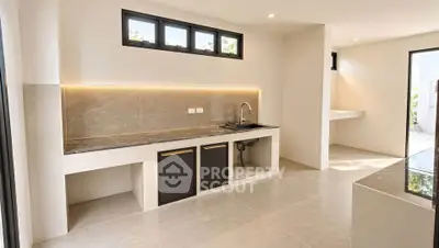 Modern kitchen with sleek design and ample natural light, featuring a minimalist aesthetic and high-end finishes.