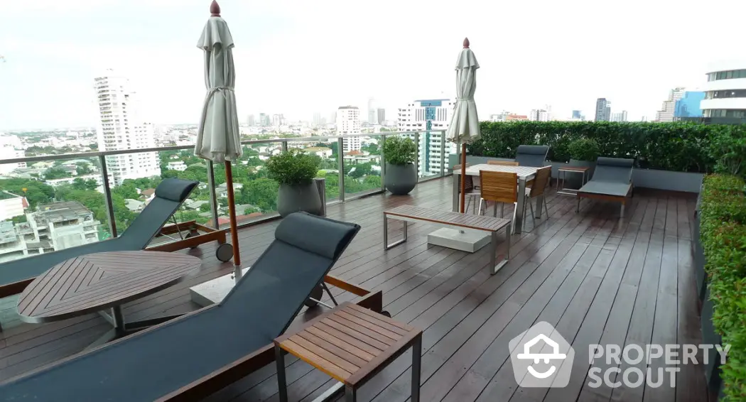 Luxurious rooftop terrace with modern lounge chairs and city skyline view.