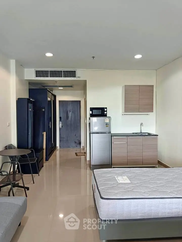 Modern studio apartment with sleek kitchen and cozy living area, perfect for urban living.