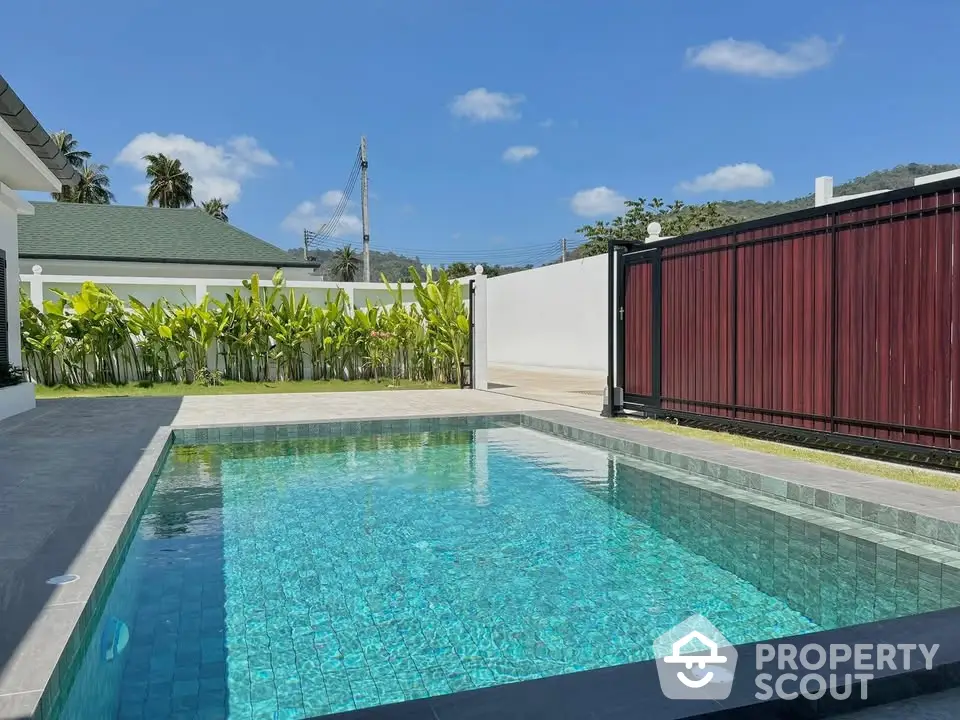 Stunning private pool with lush greenery and modern fencing in a serene residential setting.