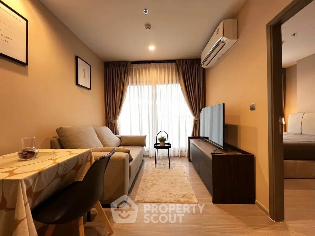 Cozy living room with modern decor and natural light, featuring a comfortable sofa and flat-screen TV.