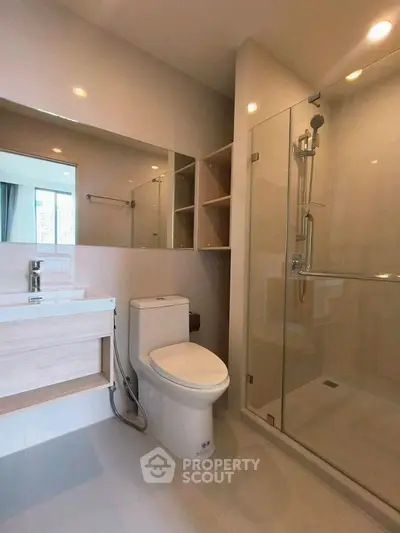 Modern bathroom with glass shower and sleek fixtures in a contemporary apartment.