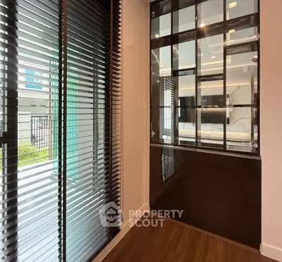 Modern interior with sleek glass cabinet and large window blinds, offering a stylish and contemporary living space.