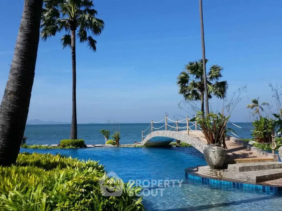 Luxurious beachfront pool with stunning ocean view and tropical landscaping.