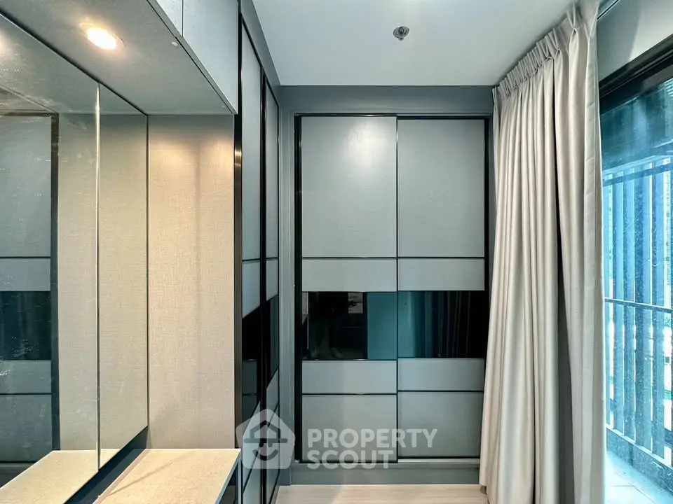 Modern bedroom with sleek built-in wardrobe and large window for natural light.