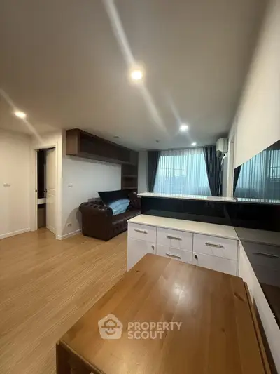 Modern living room with wooden flooring and stylish furniture in a cozy apartment setting.