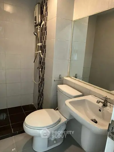 Modern bathroom with sleek fixtures and shower in a compact layout.