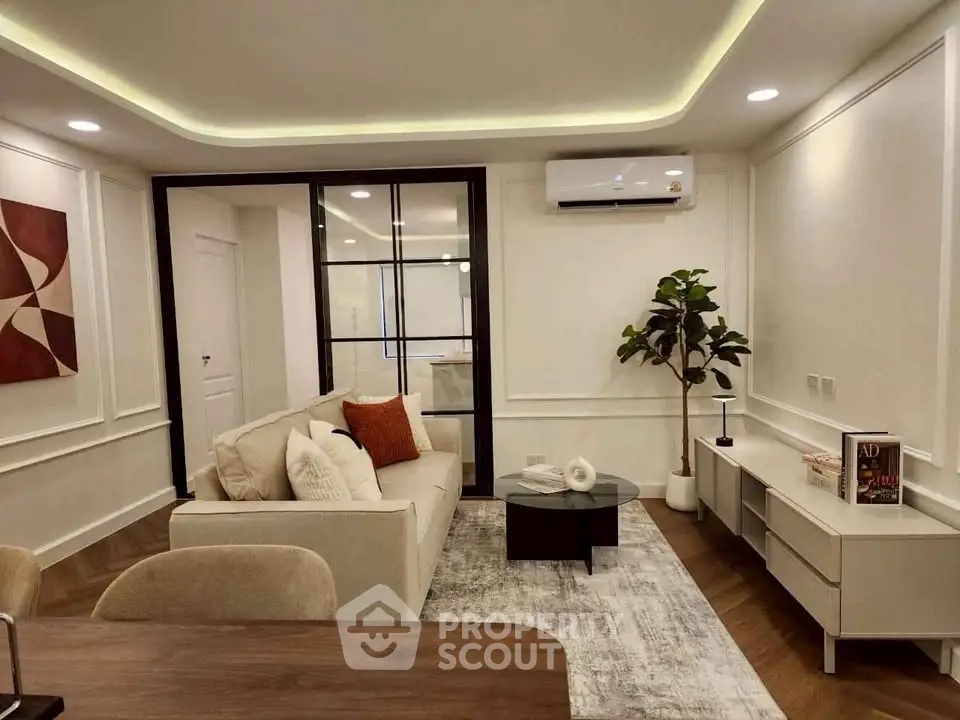 Modern living room with stylish decor and air conditioning, featuring a cozy sofa and elegant lighting.