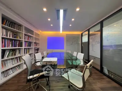 Modern study room with glass table and bookshelves, ideal for meetings and brainstorming sessions.