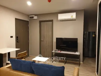 Modern living room with air conditioning and flat-screen TV, featuring stylish furniture and wooden flooring.