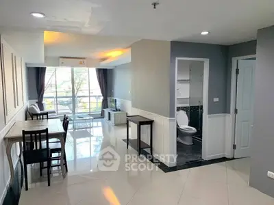 Spacious open-plan living area with modern dining set and large windows for natural light.