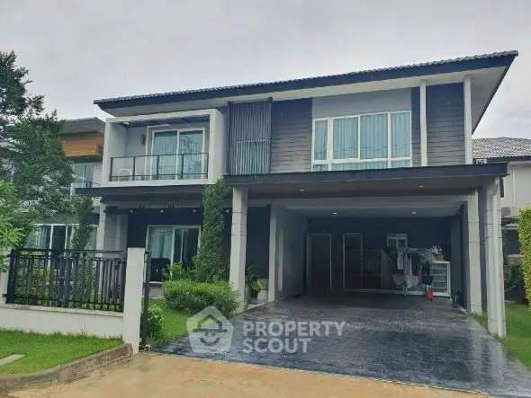 Modern two-story house with spacious driveway and lush greenery