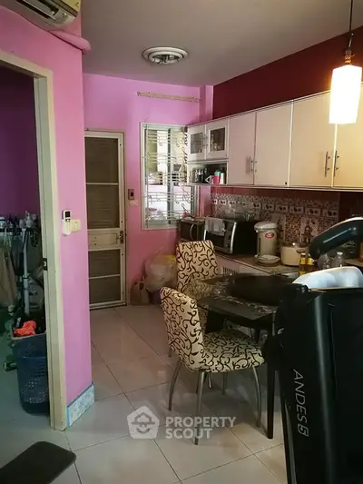Charming kitchen with vibrant pink walls and modern appliances in cozy home