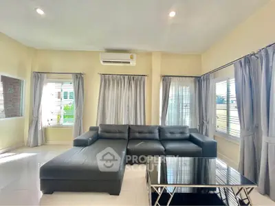 Spacious living room with modern L-shaped sofa and large windows for natural light.