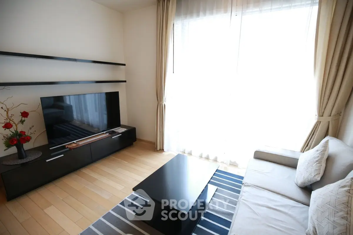 Modern living room with sleek furniture and large window for natural light