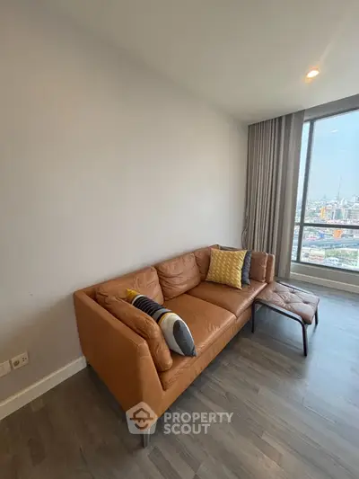 Modern living room with leather sofa and city view from large window