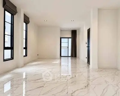 Spacious modern living room with elegant marble flooring and large windows.