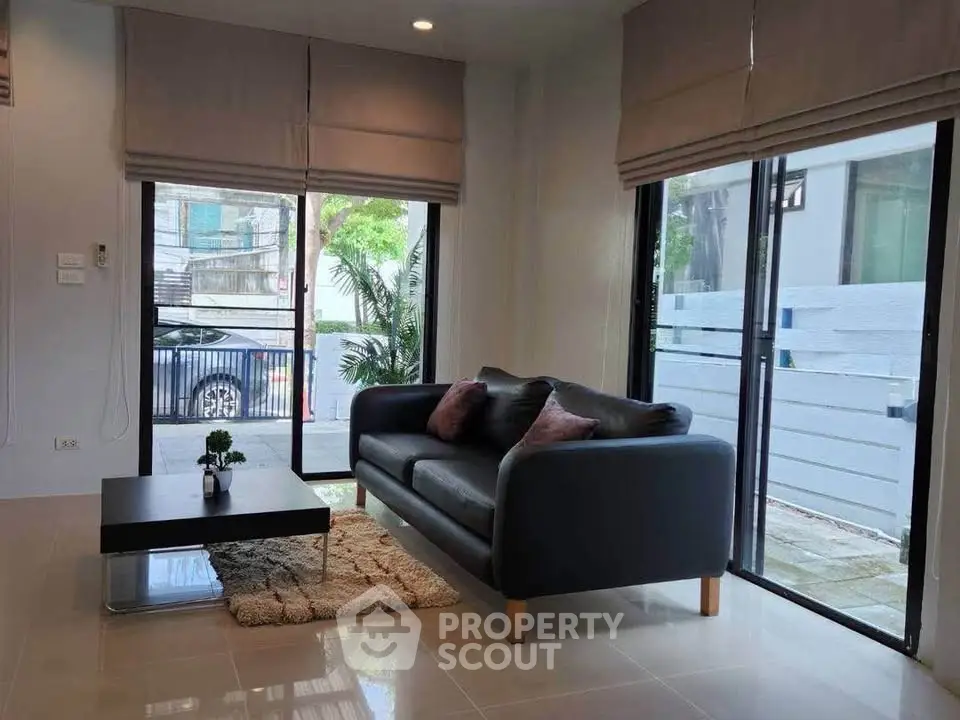 Modern living room with large windows and stylish furniture in a bright, airy space.