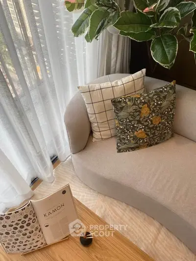 Stylish living room corner with elegant sofa and decorative pillows, perfect for relaxation.
