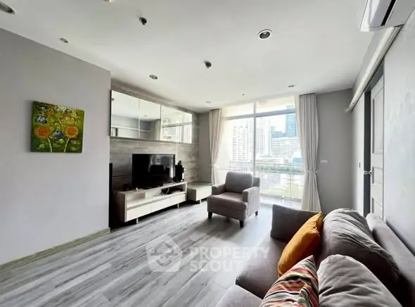 Modern living room with city view, featuring sleek furniture and large windows for natural light.