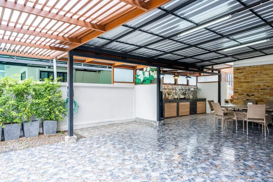 Spacious covered patio with modern outdoor kitchen and dining area.