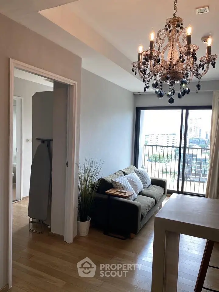 Chic living room with elegant chandelier and city view balcony