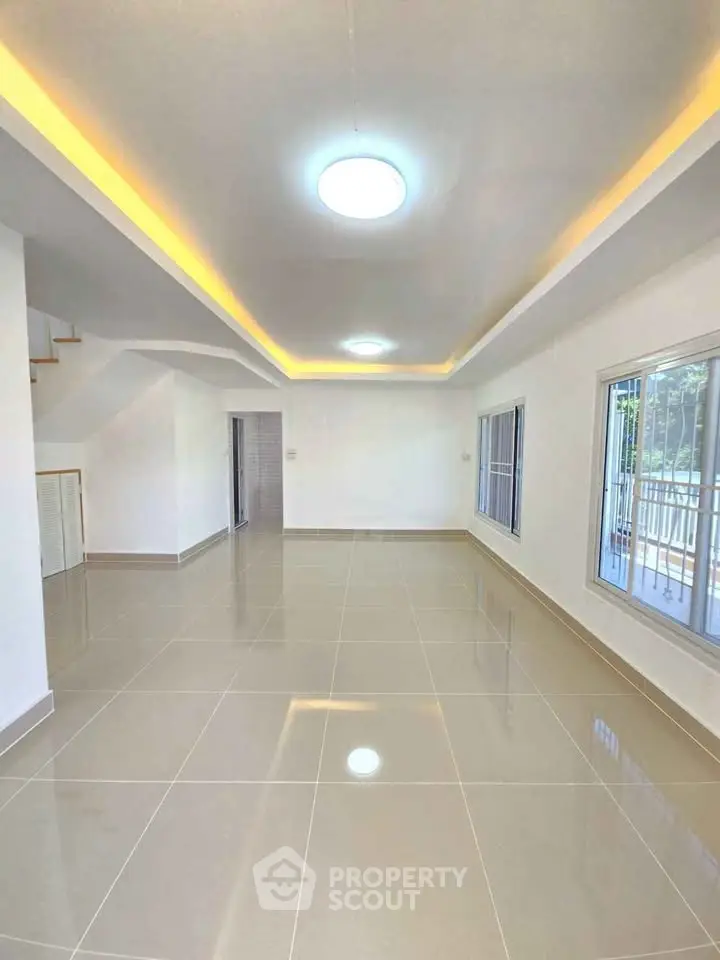 Spacious modern living room with glossy tiled floors and recessed lighting