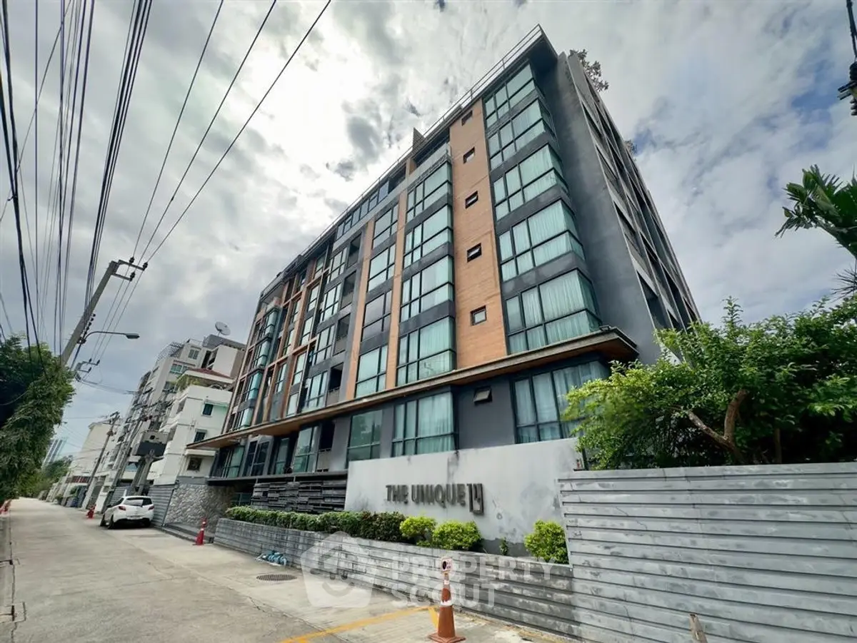 Modern urban apartment building with sleek design and lush greenery, perfect for city living.