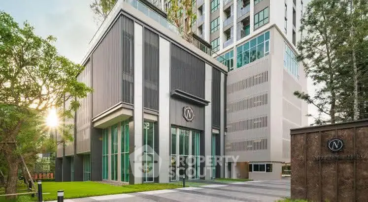Modern high-rise building with sleek exterior design and lush greenery.