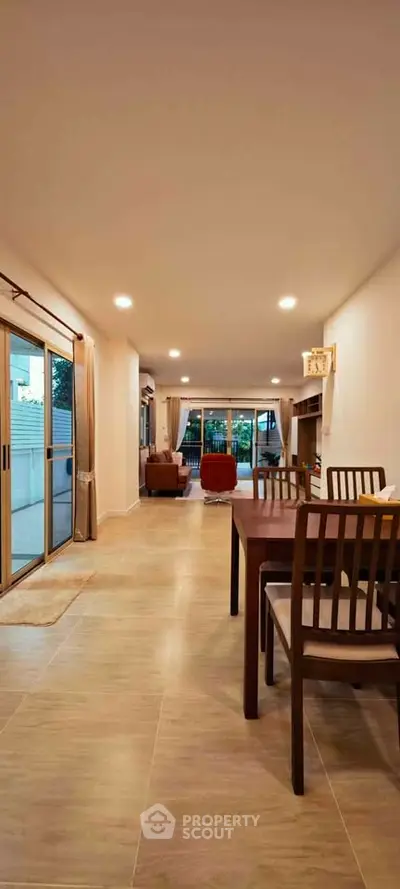 Spacious open-plan living and dining area with elegant furnishings and large windows for natural light.