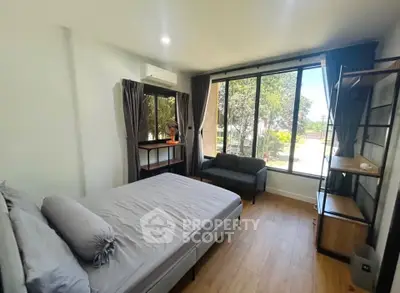 Modern bedroom with large windows and stylish decor, featuring a cozy bed and a scenic view.