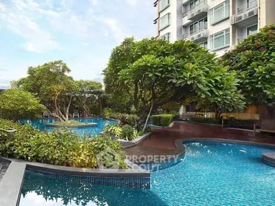 Luxurious residential building with stunning pool and lush greenery, perfect for relaxation and leisure.